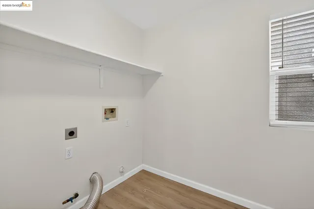a view of a small space with wooden floor and a window