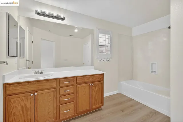 a bathroom with a tub sink and mirror