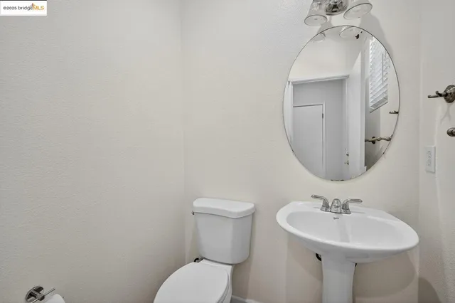 a bathroom with a sink a toilet and mirror