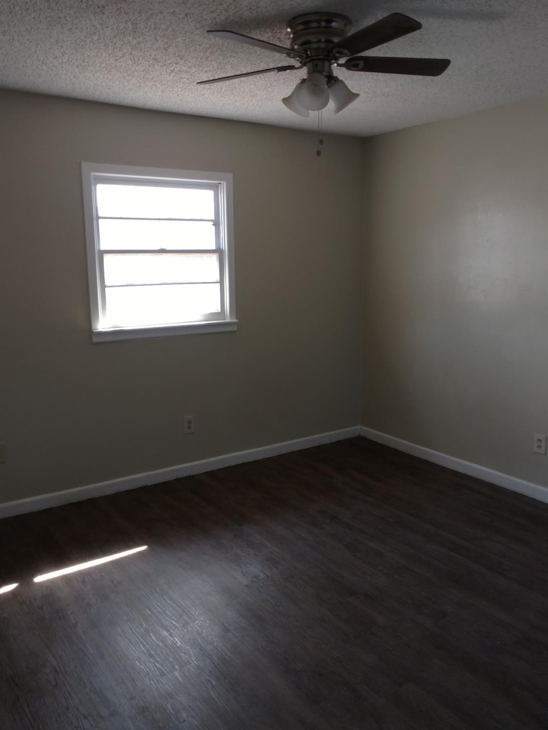 2812 43rd Street, Unit 6 Lubbock, TX 79413 - Photo 6 of 10 a view of an empty room with wooden floor and a window