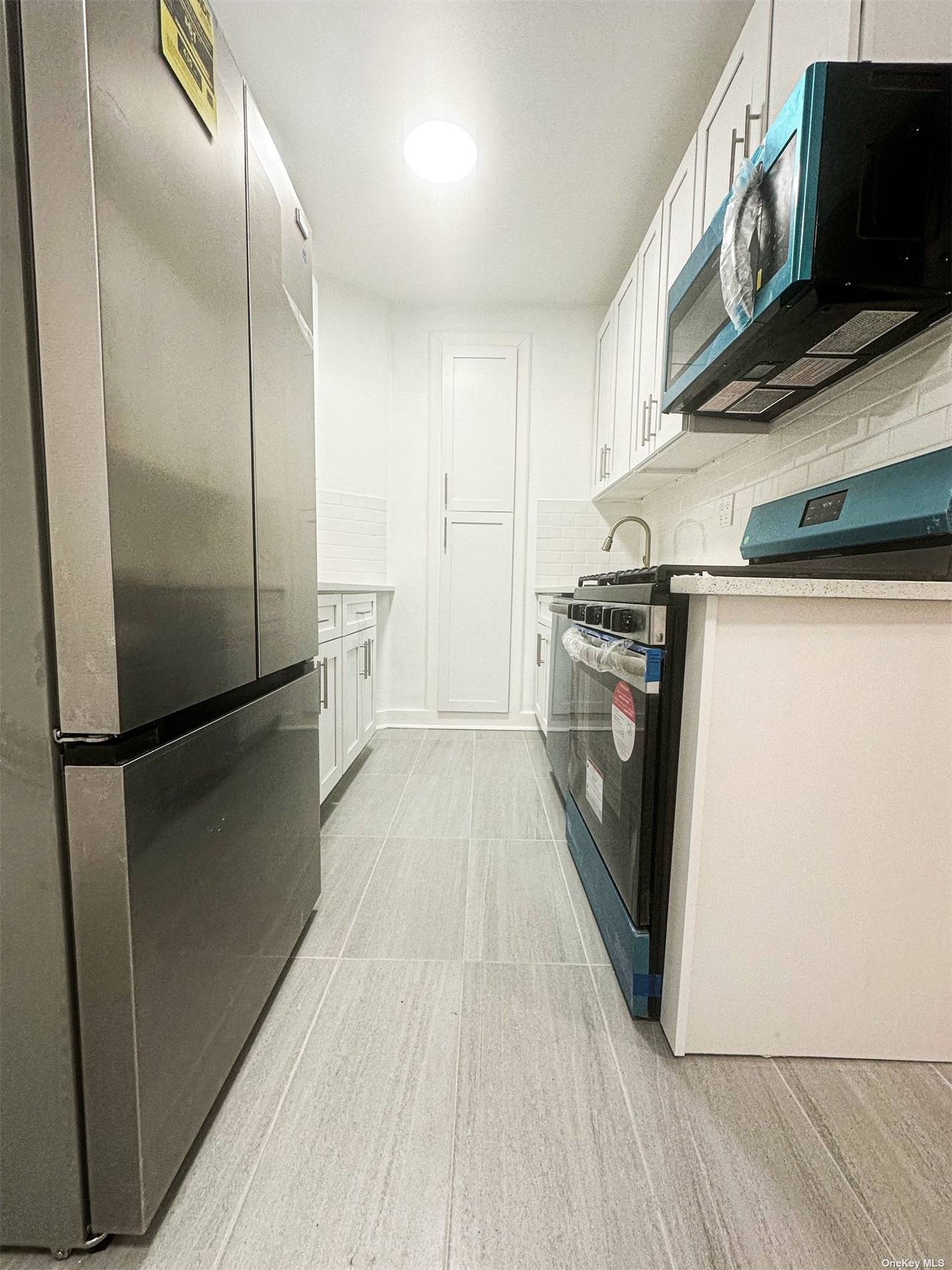 a kitchen with stainless steel appliances a refrigerator and a hard wood floor