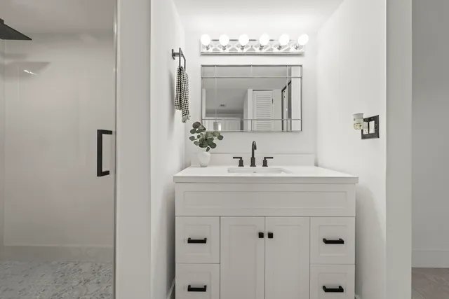 a bathroom with a sink vanity and mirror