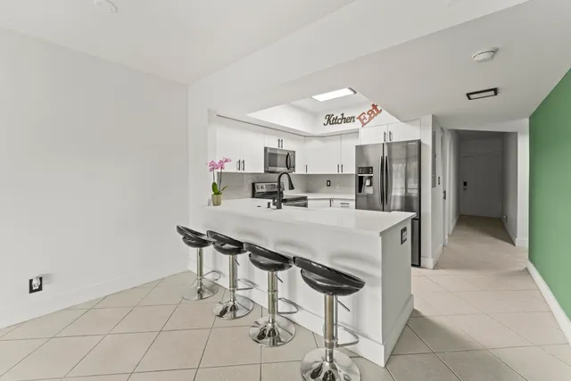 a kitchen with granite countertop a table and chairs in it