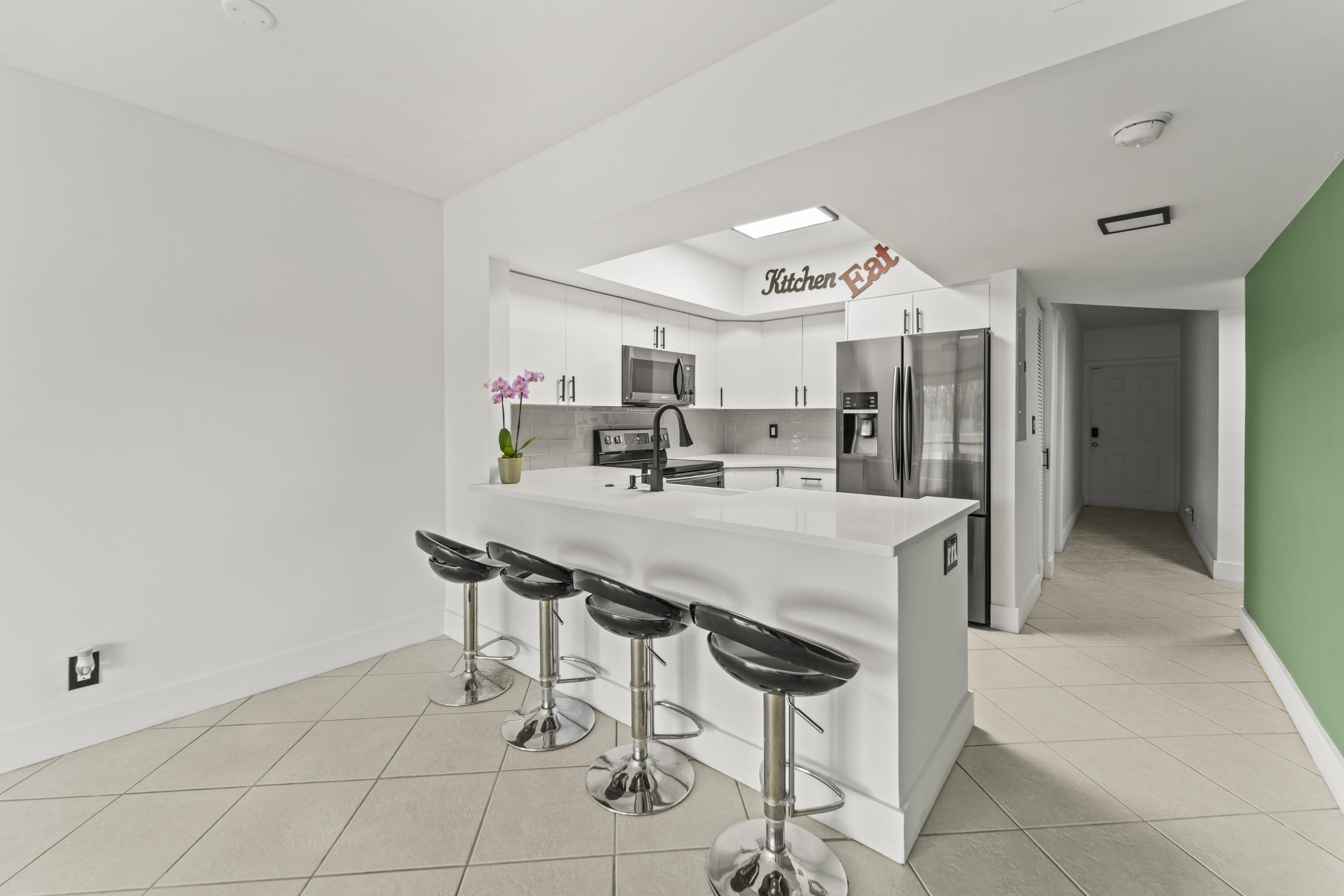 9500 Southwest 3rd Street, Unit 130 Boca Raton, FL 33428 - Photo 7 of 38 a kitchen with granite countertop a table and chairs in it