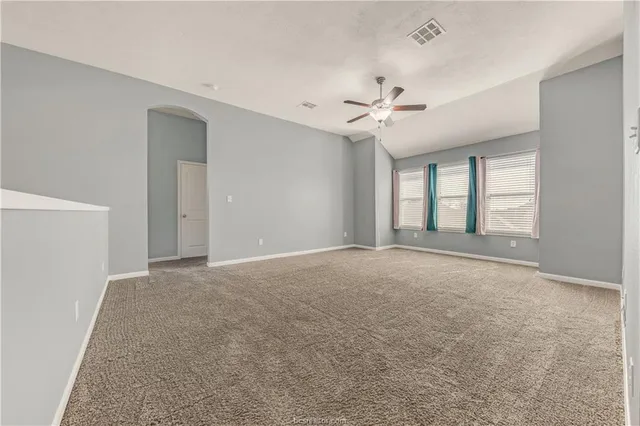 a view of a kitchen and an empty room with wooden floor a fireplace