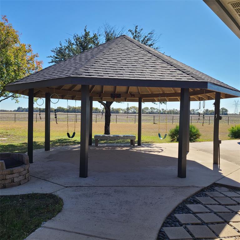 406 Epps Road Palmer, TX 75152 - Photo 27 of 36 a patio with a table and chairs under an umbrella