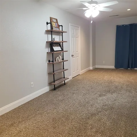 an empty room with windows and ceiling fan