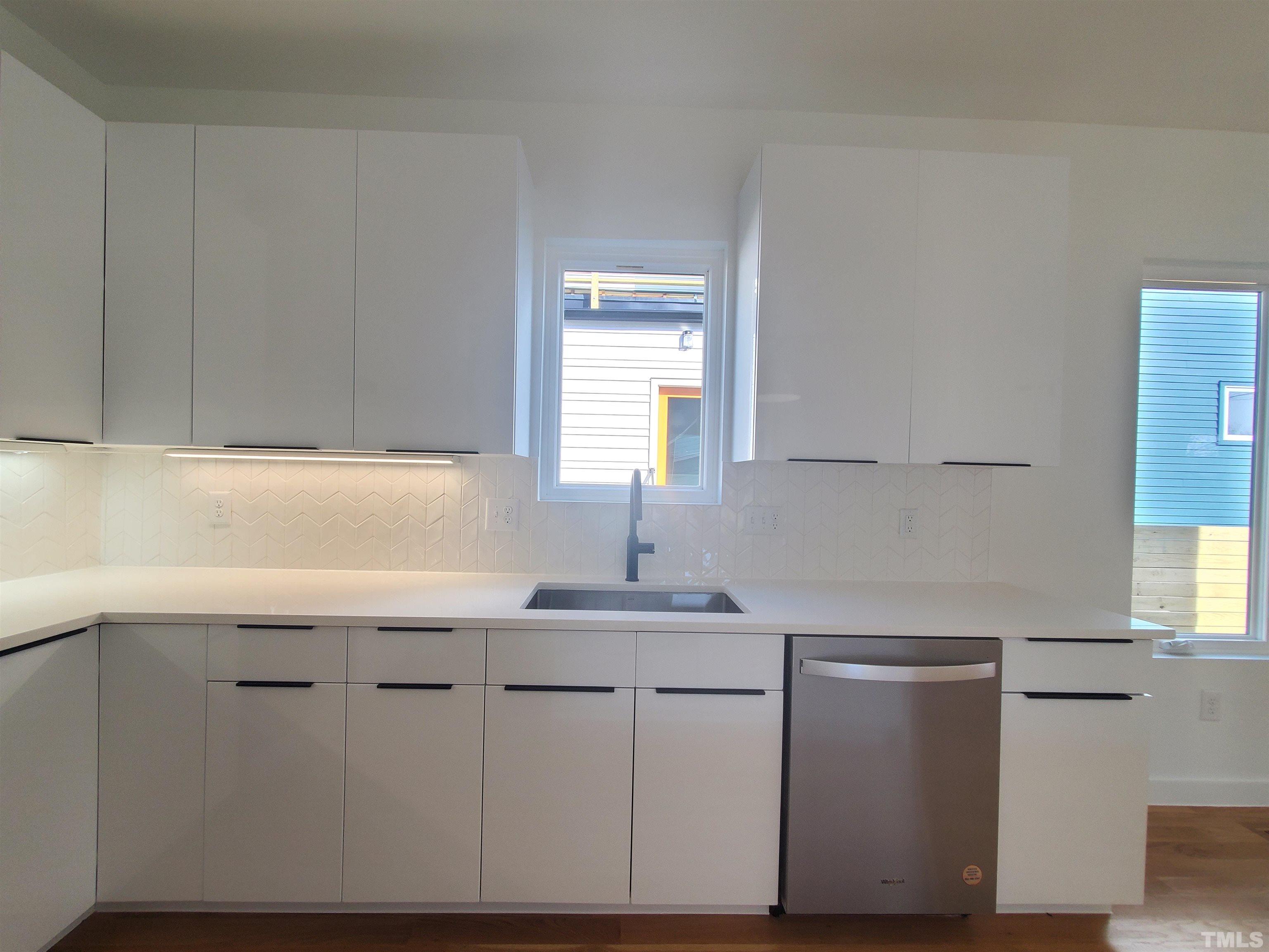 221 Bledsoe Avenue Raleigh, NC 27601 - Photo 5 of 28 a kitchen with white cabinets appliances a sink and a window