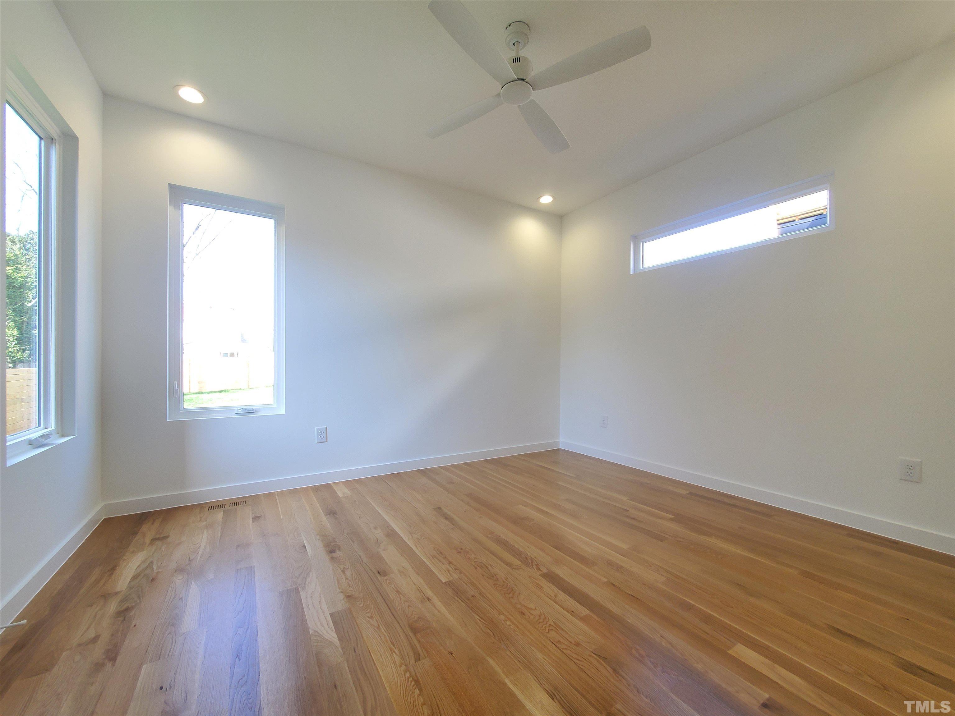 221 Bledsoe Avenue Raleigh, NC 27601 - Photo 8 of 28 an empty room with wooden floor and windows