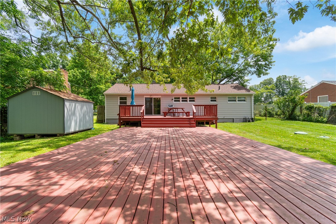 5768 Nolley Road Akron, OH 44319 - Photo 20 of 38 Expansive backyard featuring a red-stained wood-finish deck, a separate raised wood-finish deck with railings, and a sliding glass door entry to the property