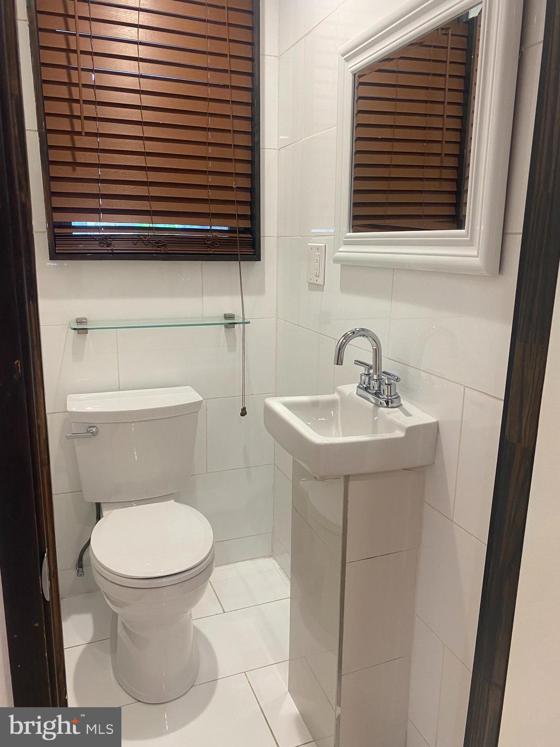 2641 Tulip Street Philadelphia, PA 19125 - Photo 12 of 37 a bathroom with a toilet a sink and a window