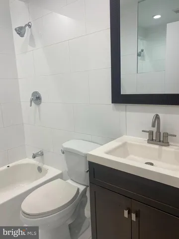 a white toilet sitting next to a bath tub