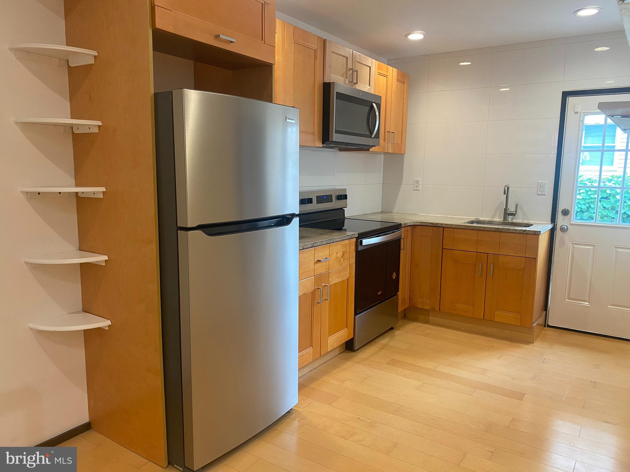 2641 Tulip Street Philadelphia, PA 19125 - Photo 8 of 37 a kitchen with stainless steel appliances a refrigerator a stove a microwave a sink and a cabinets