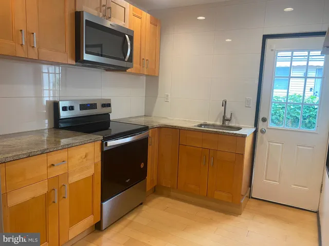 a kitchen with stainless steel appliances granite countertop a refrigerator and a stove top oven