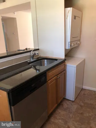 a kitchen with granite countertop a refrigerator a stove and a sink