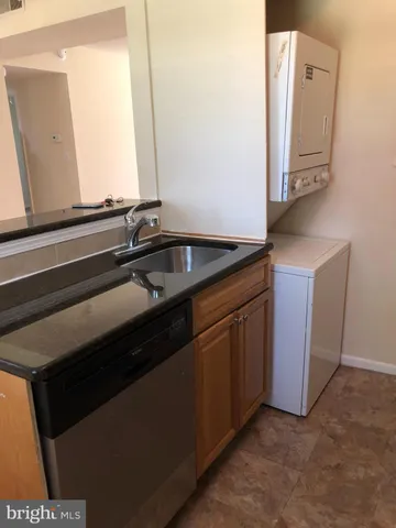 a kitchen with granite countertop a refrigerator a stove and a sink