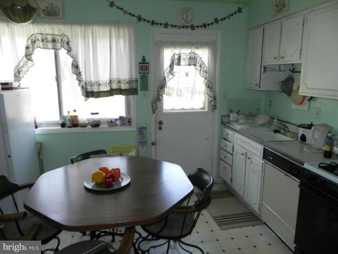 13006 Tamarack Road Silver Spring, MD 20904 - Photo 1 of 21 a kitchen with a table chairs and white appliances