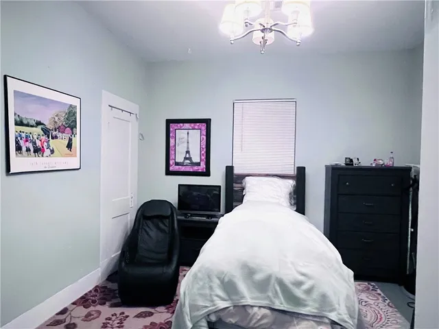 a bedroom with a bed and a chandelier