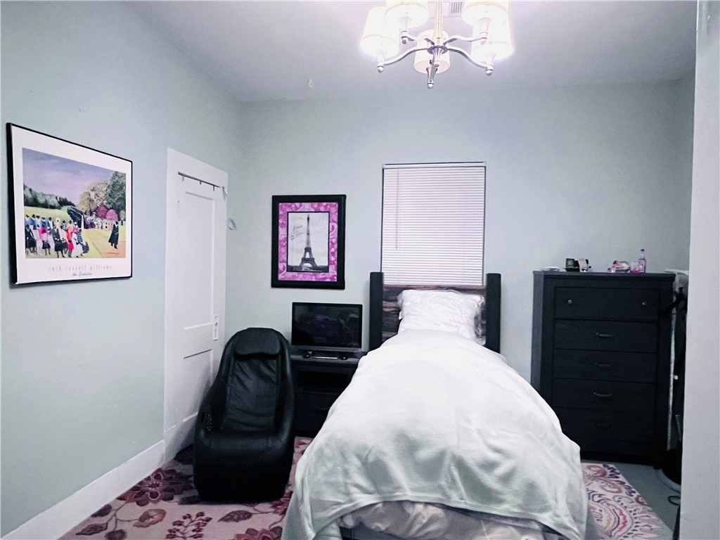 800 Ward Street Marlin, TX 76661 - Photo 19 of 22 a bedroom with a bed and a chandelier