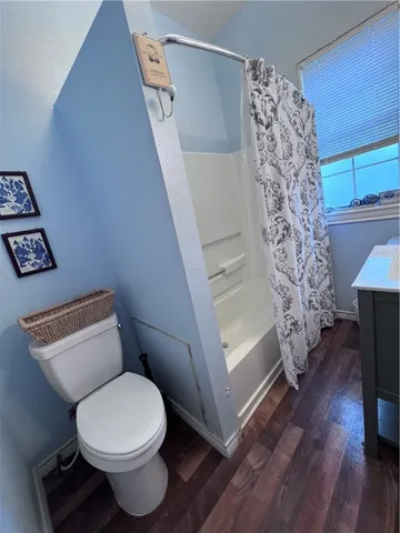 a bathroom with a toilet and a shower curtain