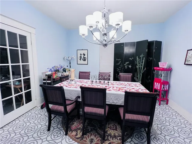 a dining room with furniture a chandelier and wooden floor