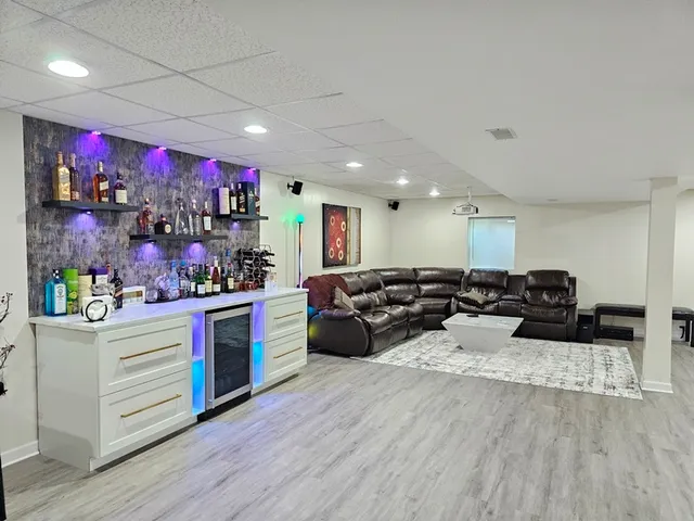 a group of people sitting in a room with kitchen view