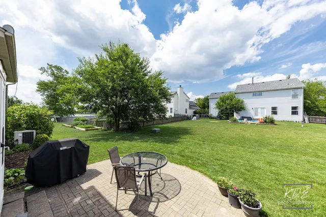 a view of a patio with table and chairs potted plants and a large tree