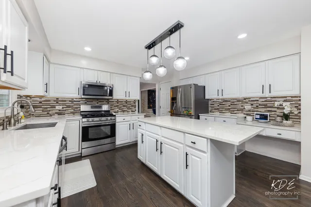 a kitchen with white cabinets and stainless steel appliances