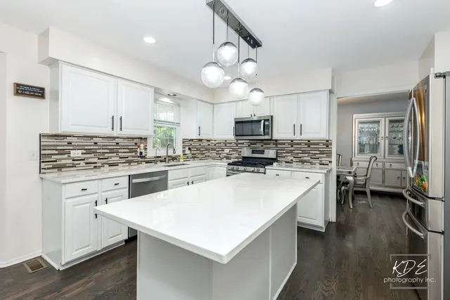a kitchen with a sink a stove top oven and refrigerator