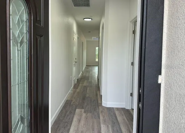 a view of a hallway with wooden floor