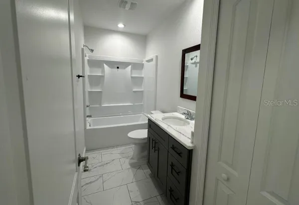 a kitchen with kitchen island granite countertop a sink dishwasher a stove and a wooden floor