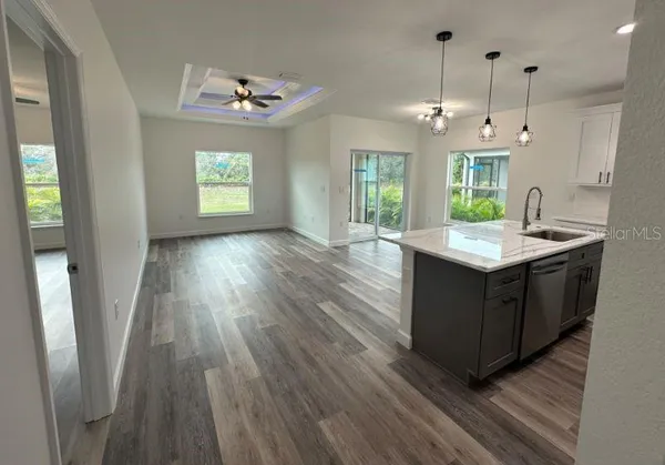 a kitchen with granite countertop a sink a counter top space and stainless steel appliances