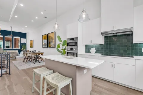 a kitchen with a dining table chairs cabinets and stainless steel appliances