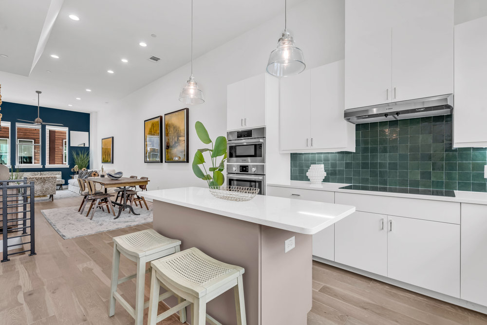 a kitchen with a dining table chairs cabinets and stainless steel appliances