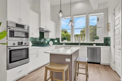 a kitchen with stainless steel appliances granite countertop a stove a sink and a refrigerator