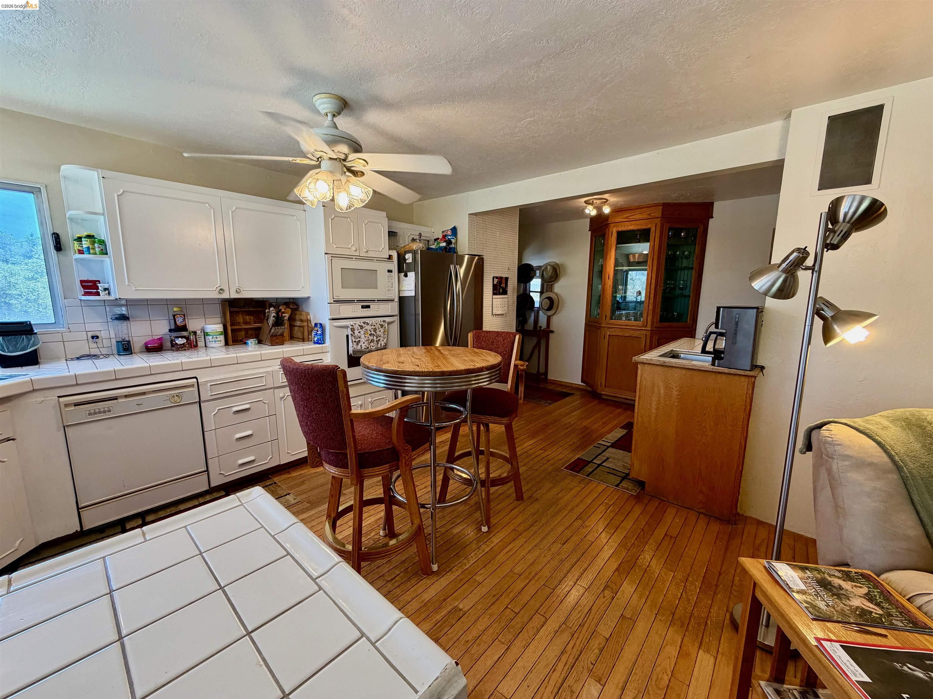 18195 Wards Ferry Road Sonora, CA 95370 - Photo 66 of 67 Kitchen featuring white cabinetry, tile countertops, and hardwood flooring