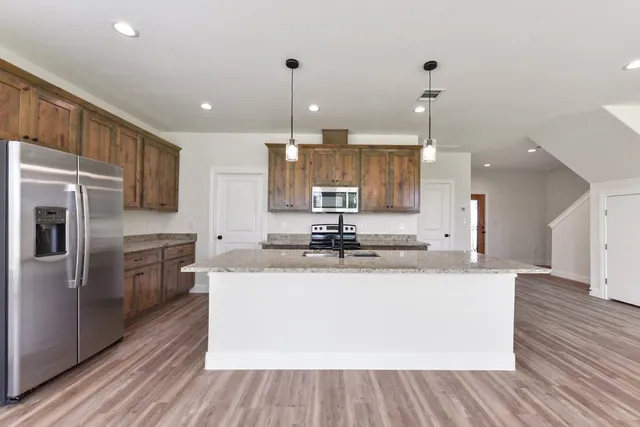 a kitchen with granite countertop a sink stainless steel appliances and cabinets