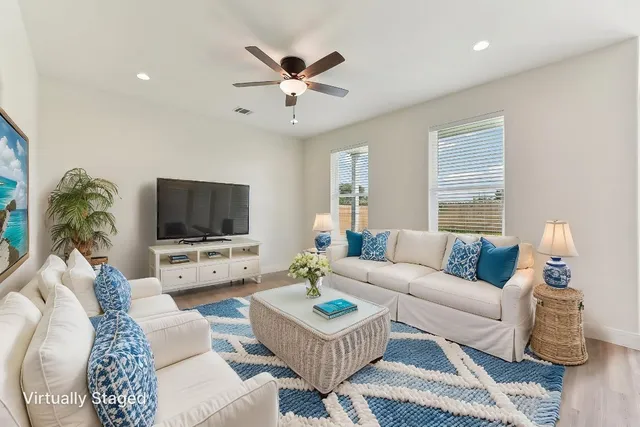 a living room with furniture a window and a flat screen tv