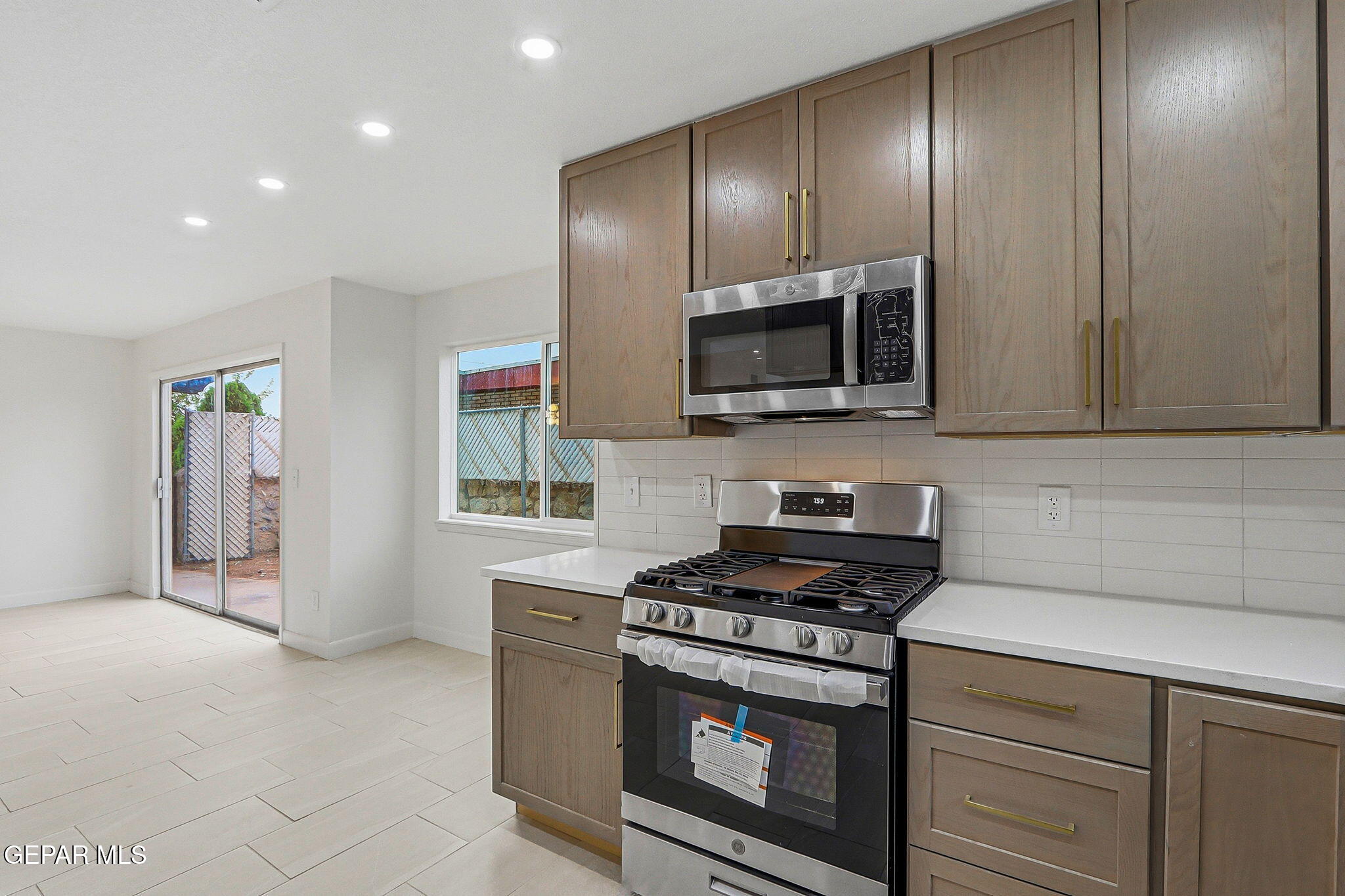 709 Frontera Road El Paso, TX 79922 - Photo 16 of 41 a kitchen with stainless steel appliances granite countertop a stove a microwave and a refrigerator