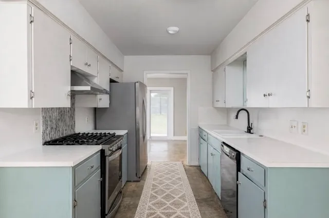 a kitchen with stainless steel appliances a sink stove and cabinets