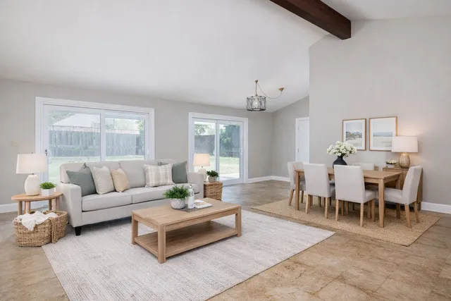 a living room with furniture dining table and a large window