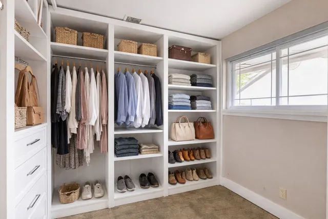 a view of walk in closet with clothes and shoes