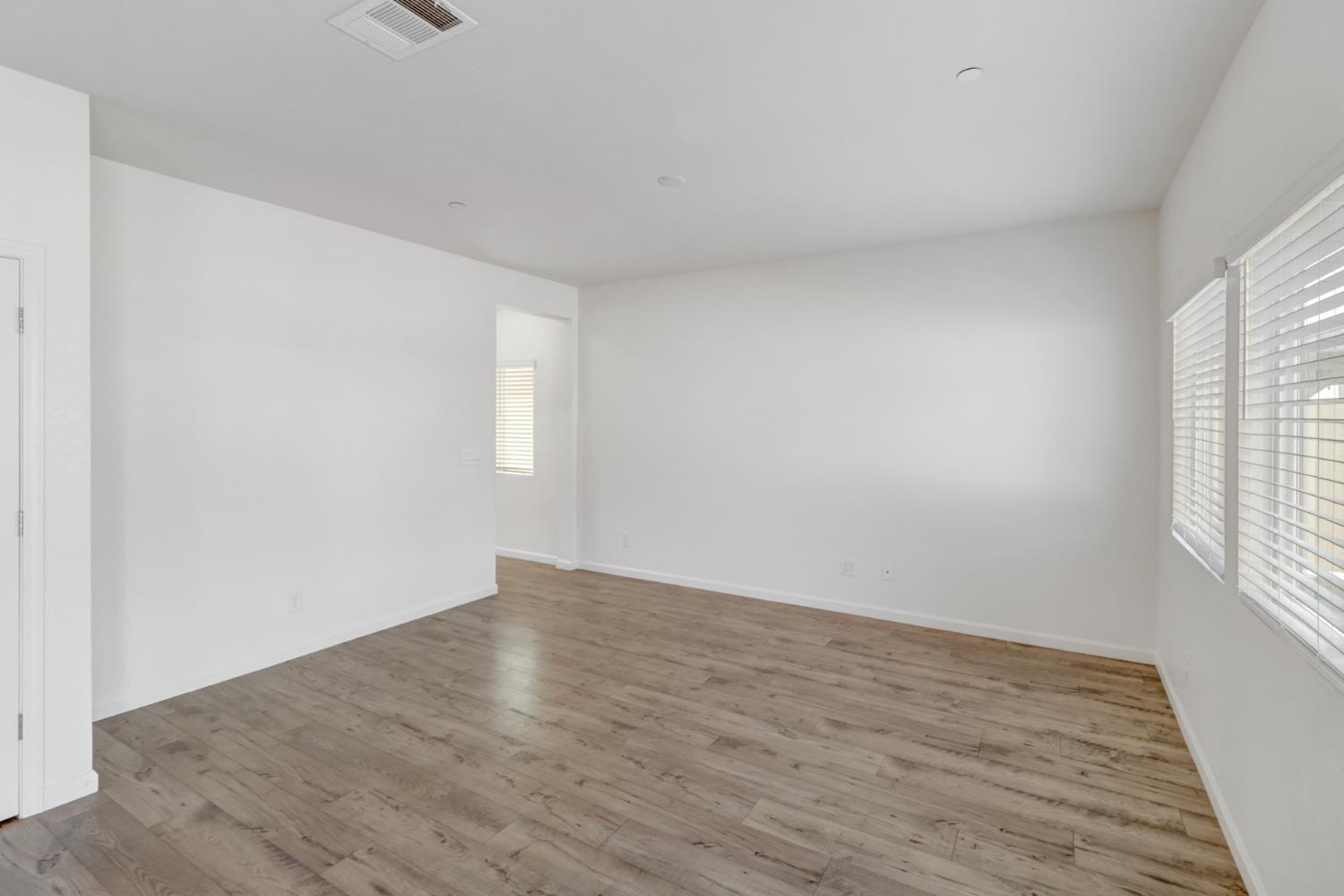 2887 Krone Way Antelope, CA 95843 - Photo 13 of 46 an empty room with wooden floor and windows