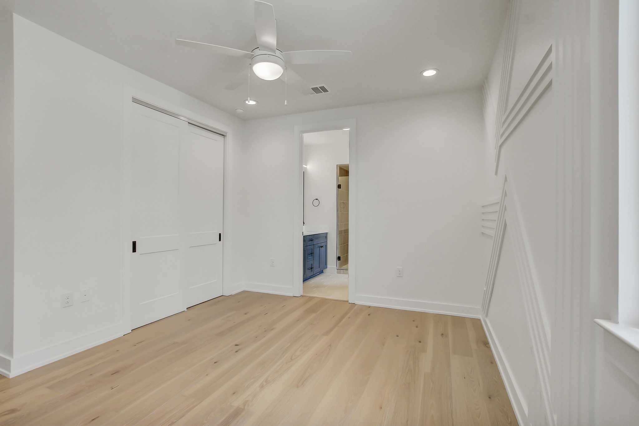 4127 East 12th Street, Unit 8 Austin, TX 78721 - Photo 19 of 32 Unfurnished bedroom featuring light wood finished floors, baseboards, recessed lighting, ensuite bathroom, and a closet