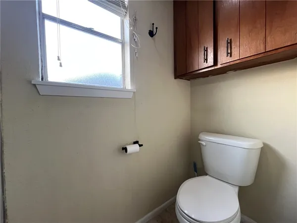 a white toilet sitting next to a window