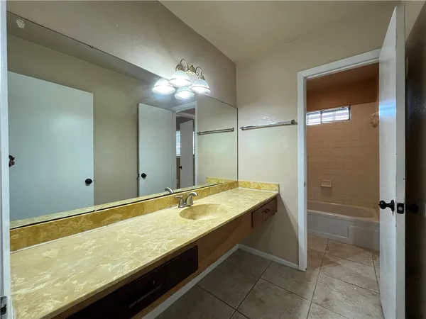 a bathroom with a granite countertop sink and a mirror