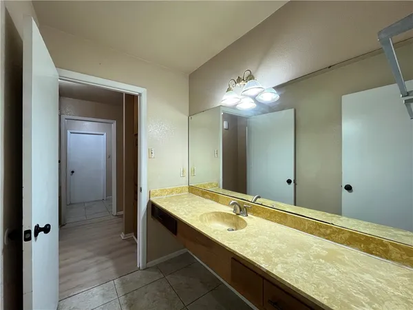 a bathroom with a granite countertop sink and a mirror