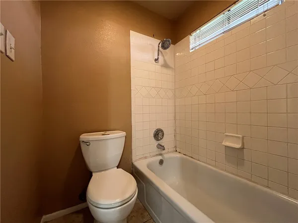 a white toilet sitting next to a bath tub