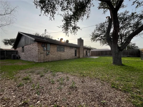 a view of a house with backyard and a tree