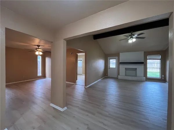 a view of a livingroom with wooden floor and a fireplace